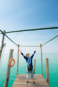 Full length of boy on sea against blue sky