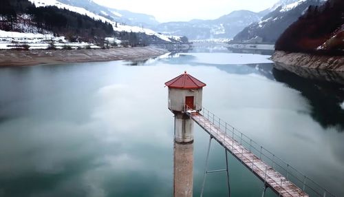 Built structure by lake against sky