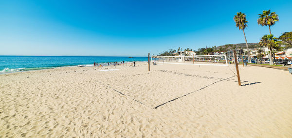 Scenic view of beach against clear blue sky