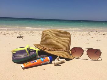 Deck chairs on sandy beach against sky