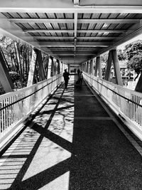 Rear view of people walking on footbridge