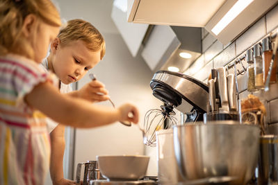 Side view of cute boy playing in kitchen