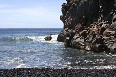 Rocks on beach against sky