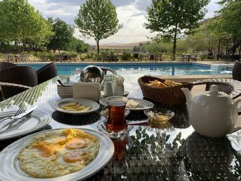 Food served on table by swimming pool
