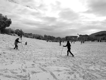 People on field against sky during winter