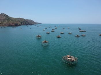 High angle view of fish cage in sea against clear sky