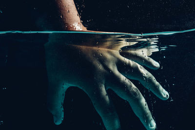 Cropped hand of man swimming in sea