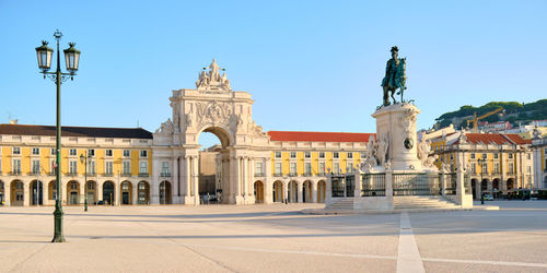 Statue in city against clear sky