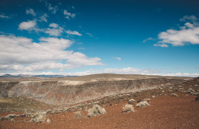 View of desert against cloudy sky