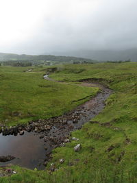 Scenic view of river by landscape against sky