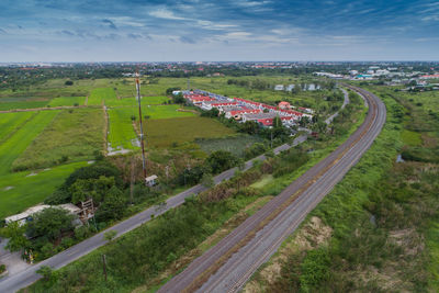 High angle view of road amidst field against sky