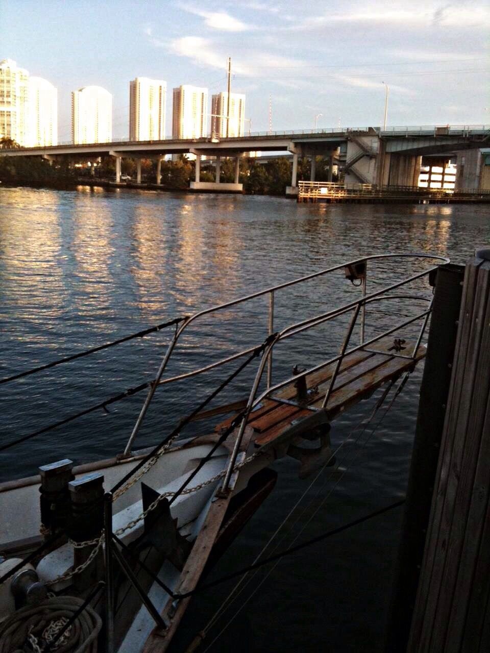 water, nautical vessel, transportation, boat, mode of transport, built structure, architecture, river, moored, building exterior, harbor, sky, city, waterfront, bridge - man made structure, sea, reflection, railing, outdoors, no people