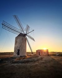 Low angle view of a windmill against sky during sunset