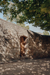 Low angle view of old building by trees against sky