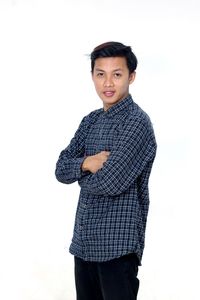 Portrait of young man standing against white background