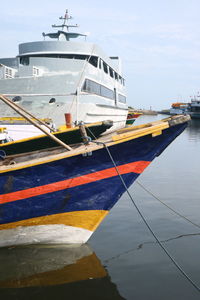 Ship moored at harbor against sky