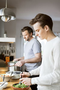 Young man and woman standing in kitchen at home