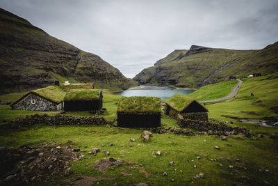 Scenic view of mountains and turf houses against sky