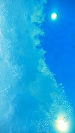 Low angle view of illuminated swimming pool against blue sky