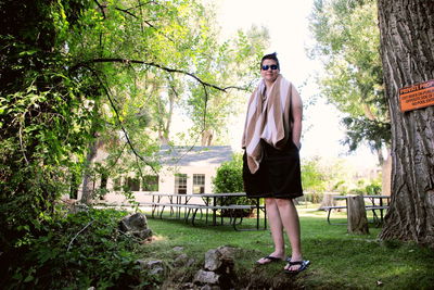 Full length of woman standing on tree trunk