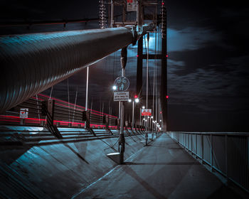 Illuminated suspension bridge against sky at night