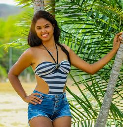 Portrait of smiling young woman standing by tree