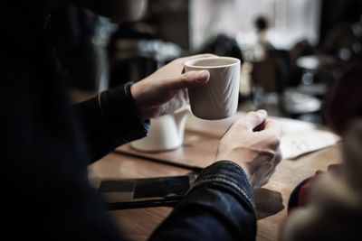 Close-up of hand holding coffee cup