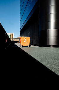 Road by building in city against sky