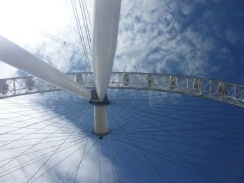 Low angle view of suspension bridge against cloudy sky