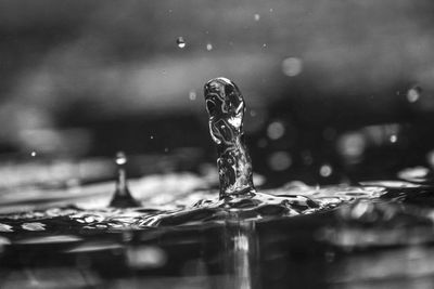 Close-up of water drop falling on glass