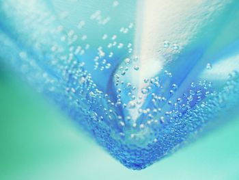 Close-up of water drops on blue glass