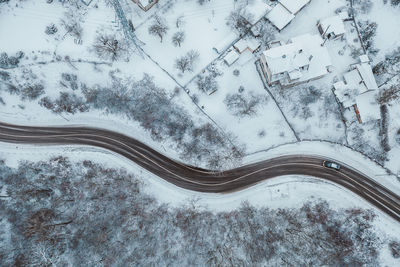 Aerial view of road amidst snow covered landscape during winter