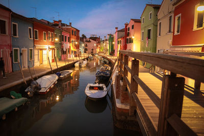 Boats moored in canal against sky