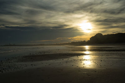 Scenic view of beach against sky during sunset