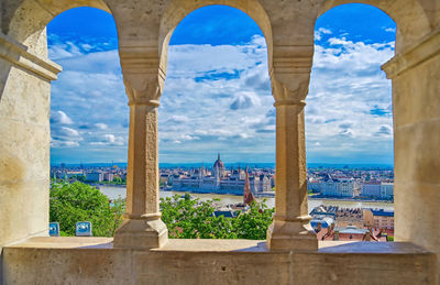 Panoramic view of buildings and city seen through arch