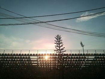 Low angle view of silhouette cables against sky during sunset
