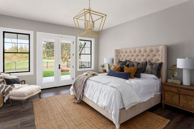 Master bedroom interior in new luxury home. french doors lead outside