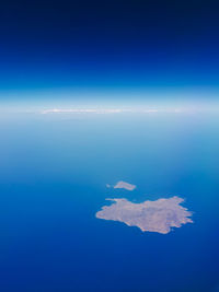 Aerial view of sea against blue sky