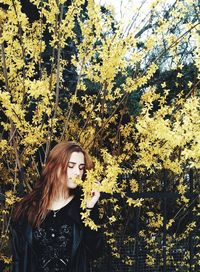 Woman smelling yellow blooming flowers