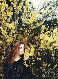 Portrait of young woman against plants