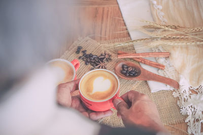 Midsection of woman holding coffee cup on table