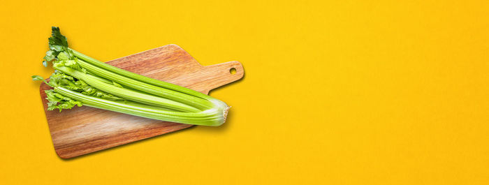 High angle view of vegetables on table against yellow background