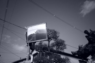 Low angle view of reflection of traffic mirror against sky
