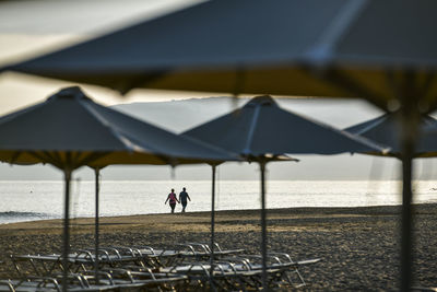 People on beach by sea against sky