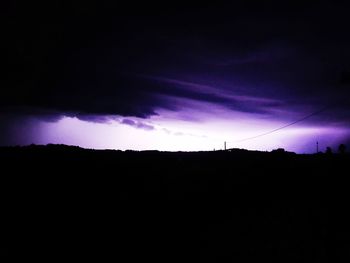 Silhouette landscape against dramatic sky at sunset