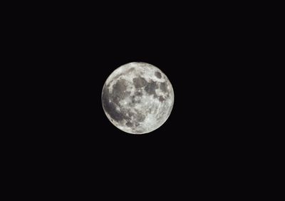 Low angle view of full moon against clear sky at night