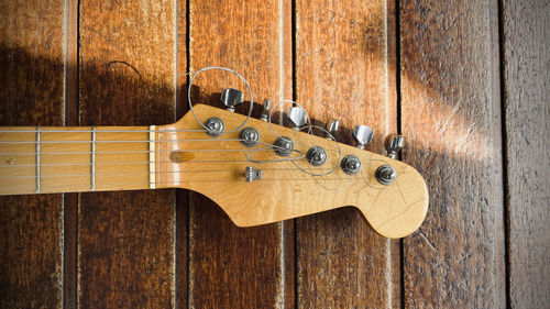 Close-up of guitar on wooden wall