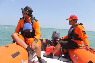 People sitting on boat in sea against sky