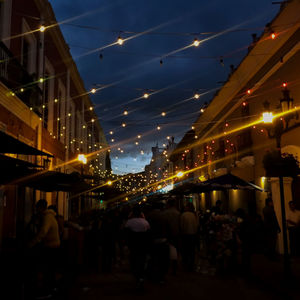 People on illuminated street at night