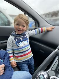 Portrait of smiling boy sitting in car
